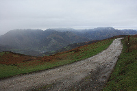 El camino desciende por una pista de tierra, dejando atrás la Sierra de Peñamayor