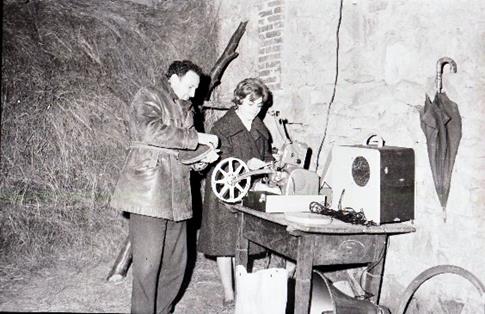 Agente de Extensión Agraria y de Economía Doméstica preparando una proyección . Monforte de Lemos ( Lugo),1961. Autor : Quiñones
